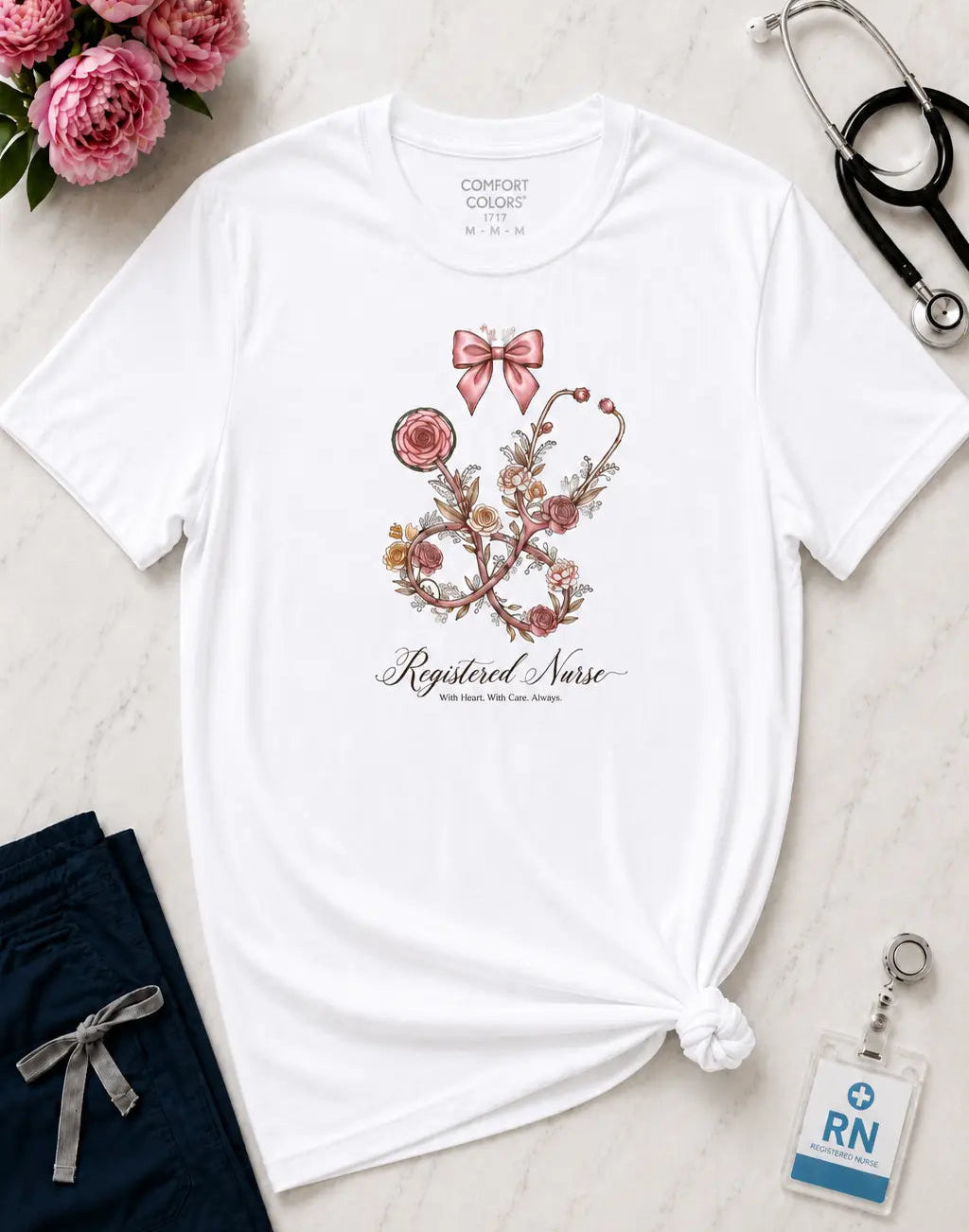 White t-shirt with floral design and 'Registered Nurse' text, accompanied by a stethoscope, flowers, and an RN badge on a light surface.